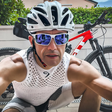 Ciclista con casco e occhiali da sole durante allenamento in bicicletta per fitness e resistenza aerobica