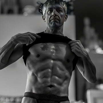 Uomo atletico che mostra addominali definiti durante allenamento fitness per forza e definizione muscolare