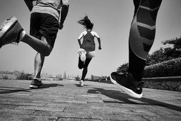 Persone che corrono all’aperto durante allenamento di running per fitness, resistenza e benessere cardiovascolare